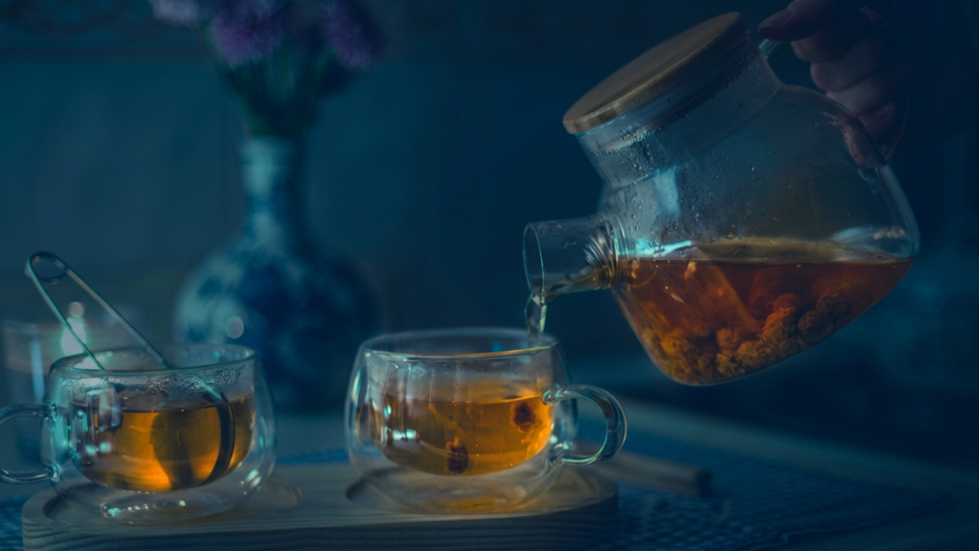Assam tea being poured from a glass teapot into glass cups, representing Japan-India investment relations and Northeast India economic opportunity 2026